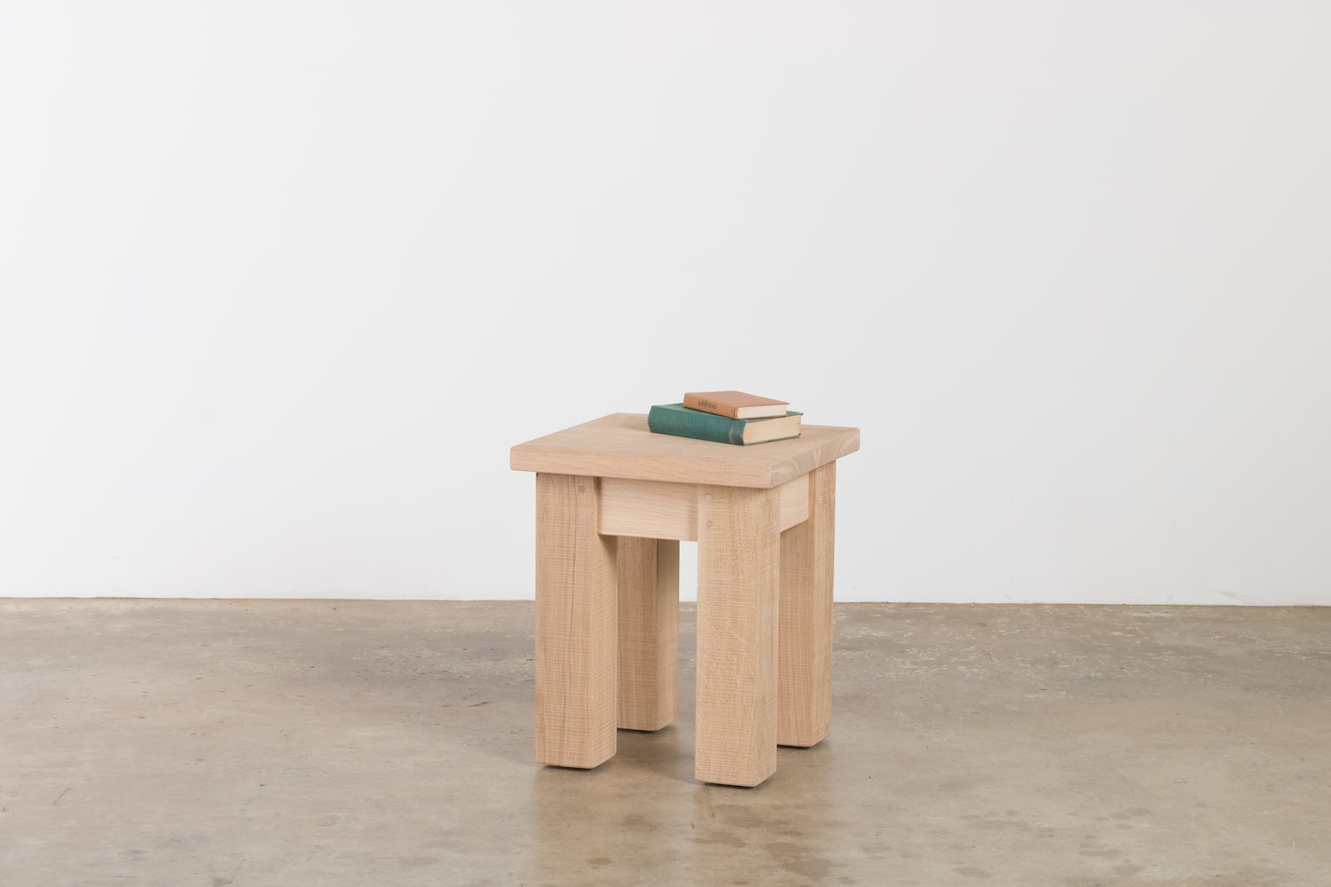 A solid oak lamp table with 2 books on top