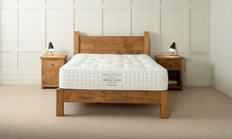 A pine bed with luxury mattress and wooden bedsides
