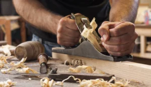 Carpenter planing wooden bed parts