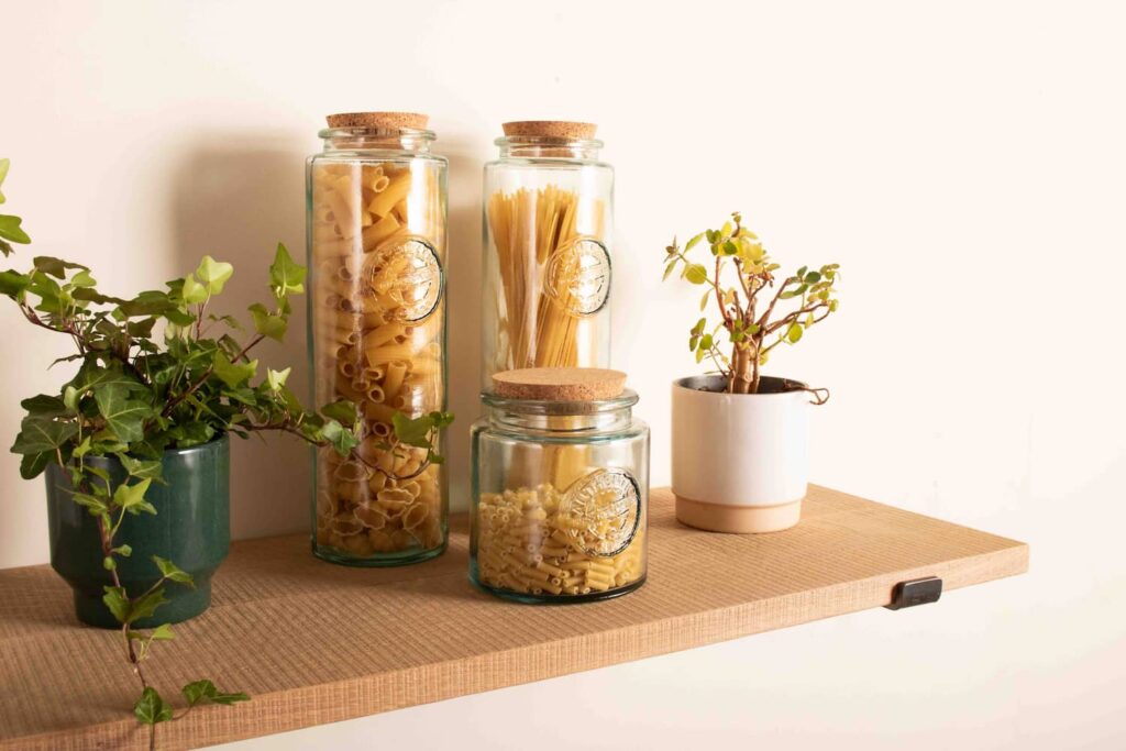 a modern rustic solid oak shelf with a display that features glass jars with pasta in and pot plants