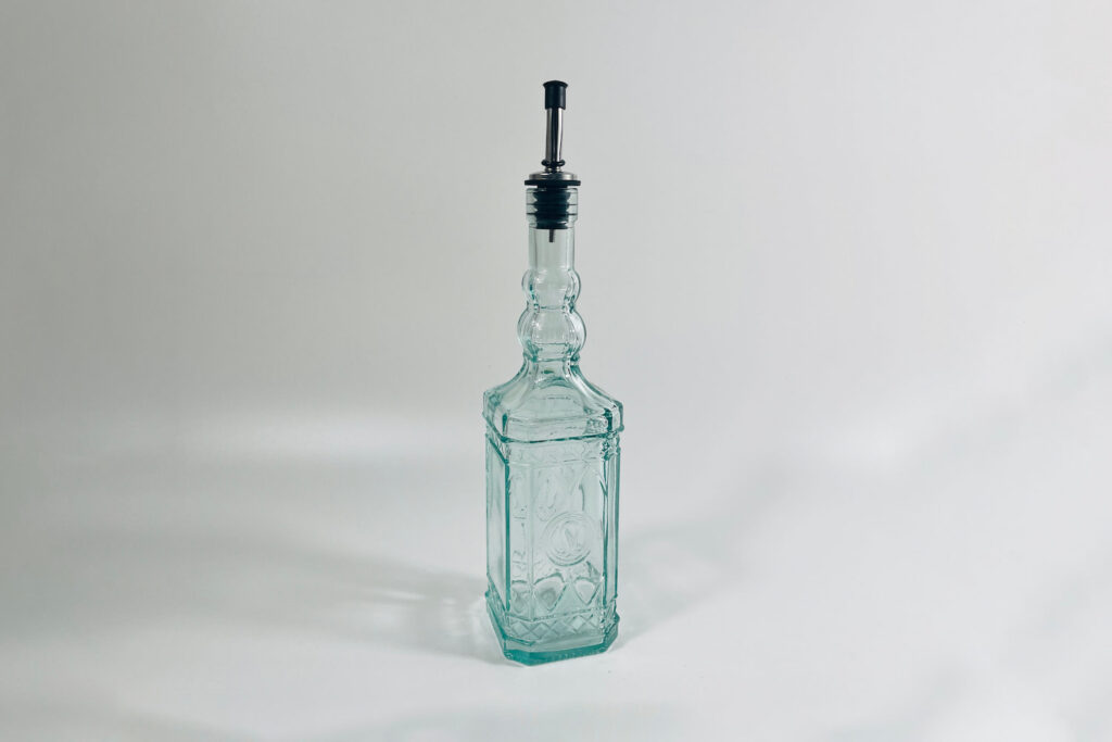 a glass oil bottle made from recycled glass