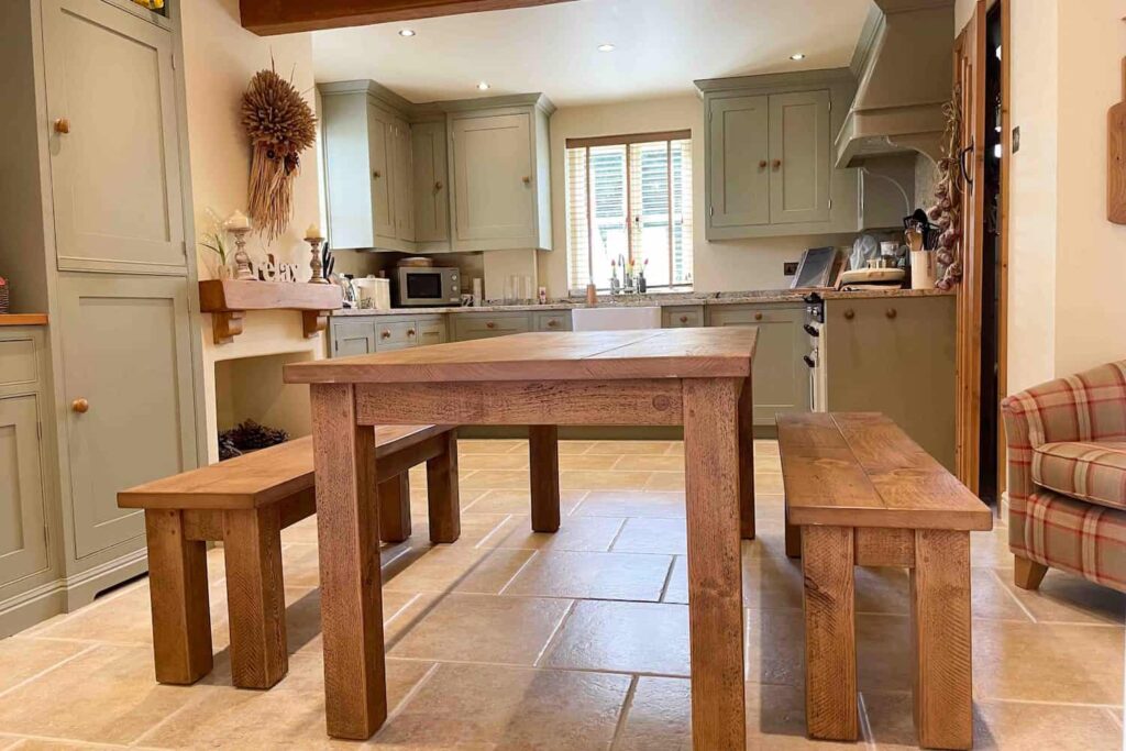 A farmhouse style rustic wooden dining table in a country cottage kitchen