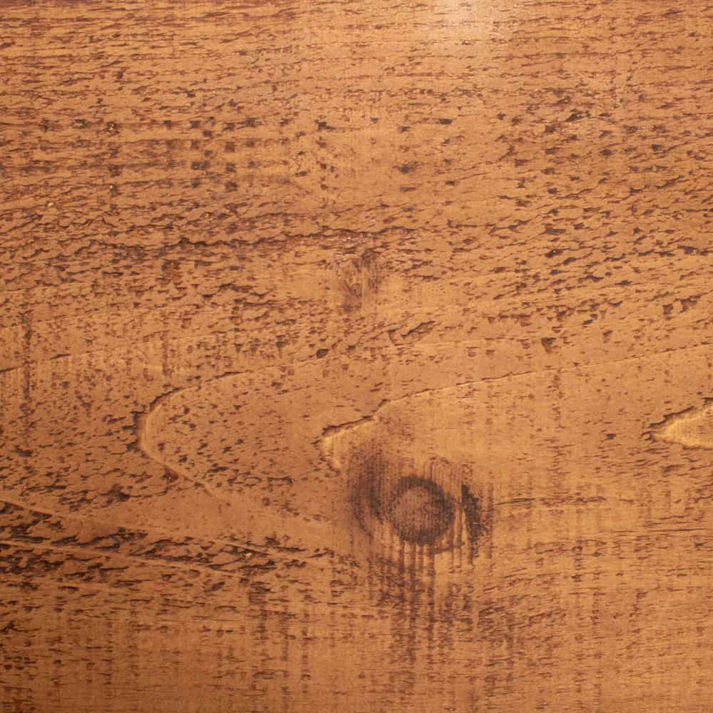 A close up of a wooden bedpost that features unique character in the knots and wood grain.