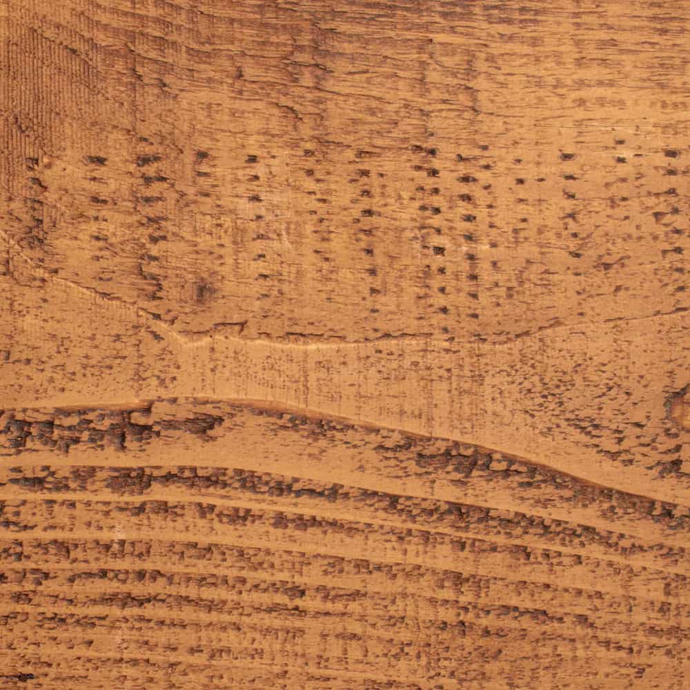 A close up of a wooden bedpost that features unique character in the knots and wood grain.