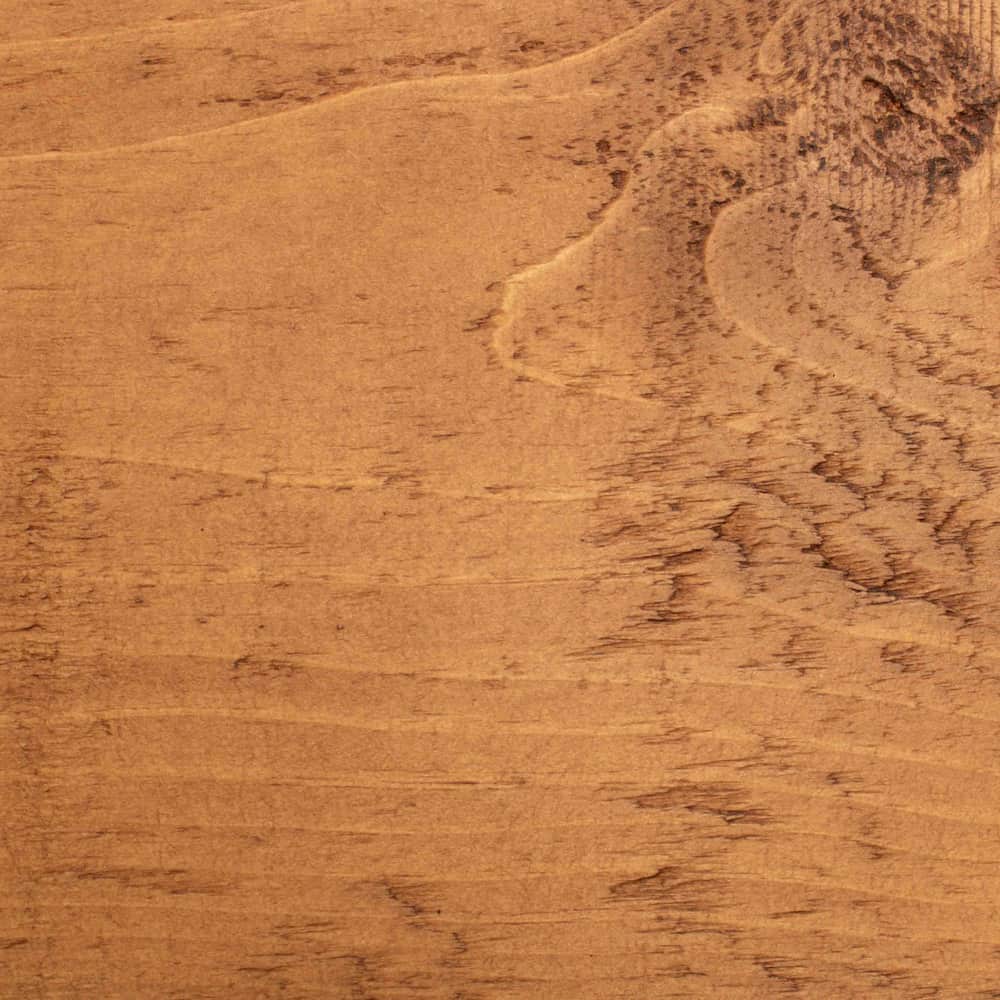 A close up of a wooden bedpost that features unique character in the knots and wood grain.
