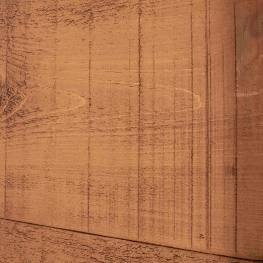 A close up of a wooden bedpost that features unique rustic saw marks
