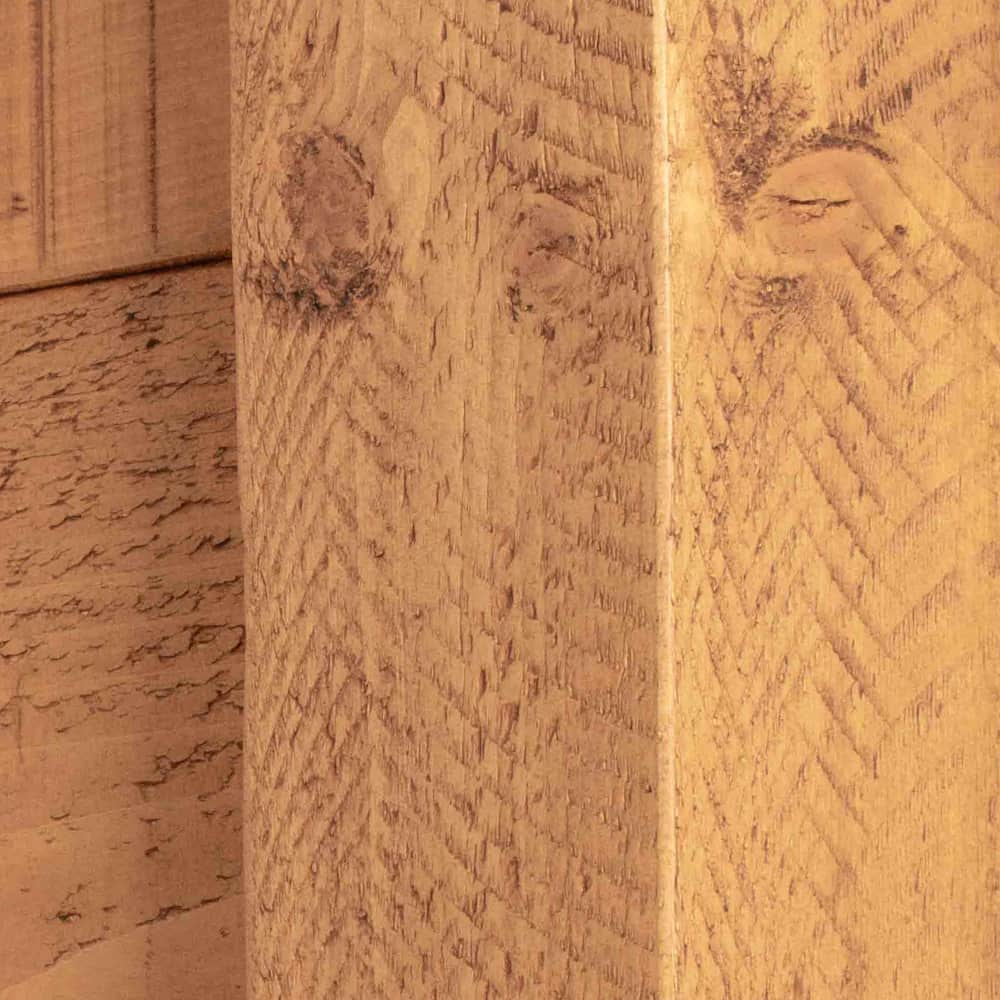 A close up of a wooden bedpost that features unique rustic saw marks